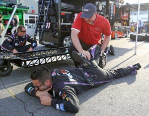 PA Bill Heisel examining injuries in pit crew members