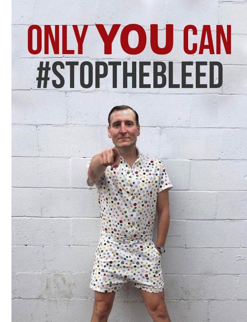 Hombre posando con el meme que el equipo del Día Nacional Detener el Sangrado creó para promocionar el evento