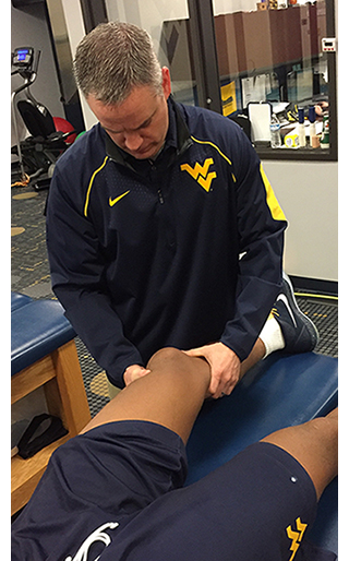 Travis Randolph examinando a un estudiante atleta