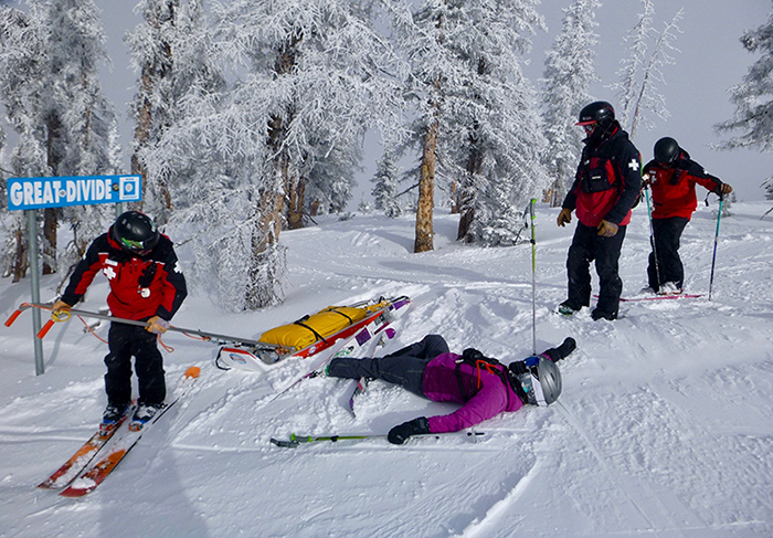Rachel Weinzimmer, interpretando a una esquiadora con una lesión en el cuello, capacitando al nuevo personal de patrulla de esquí en evaluación y tratamiento médicos