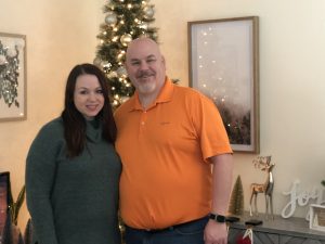 Imagen de Molly y Michael Feeney parados frente a su árbol de Navidad