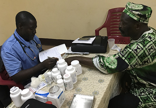 Samuel Ndinjiakat con un paciente en Ndop, Camerún