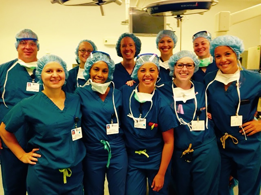 A group of residents dressed in scrubs pose in an OR