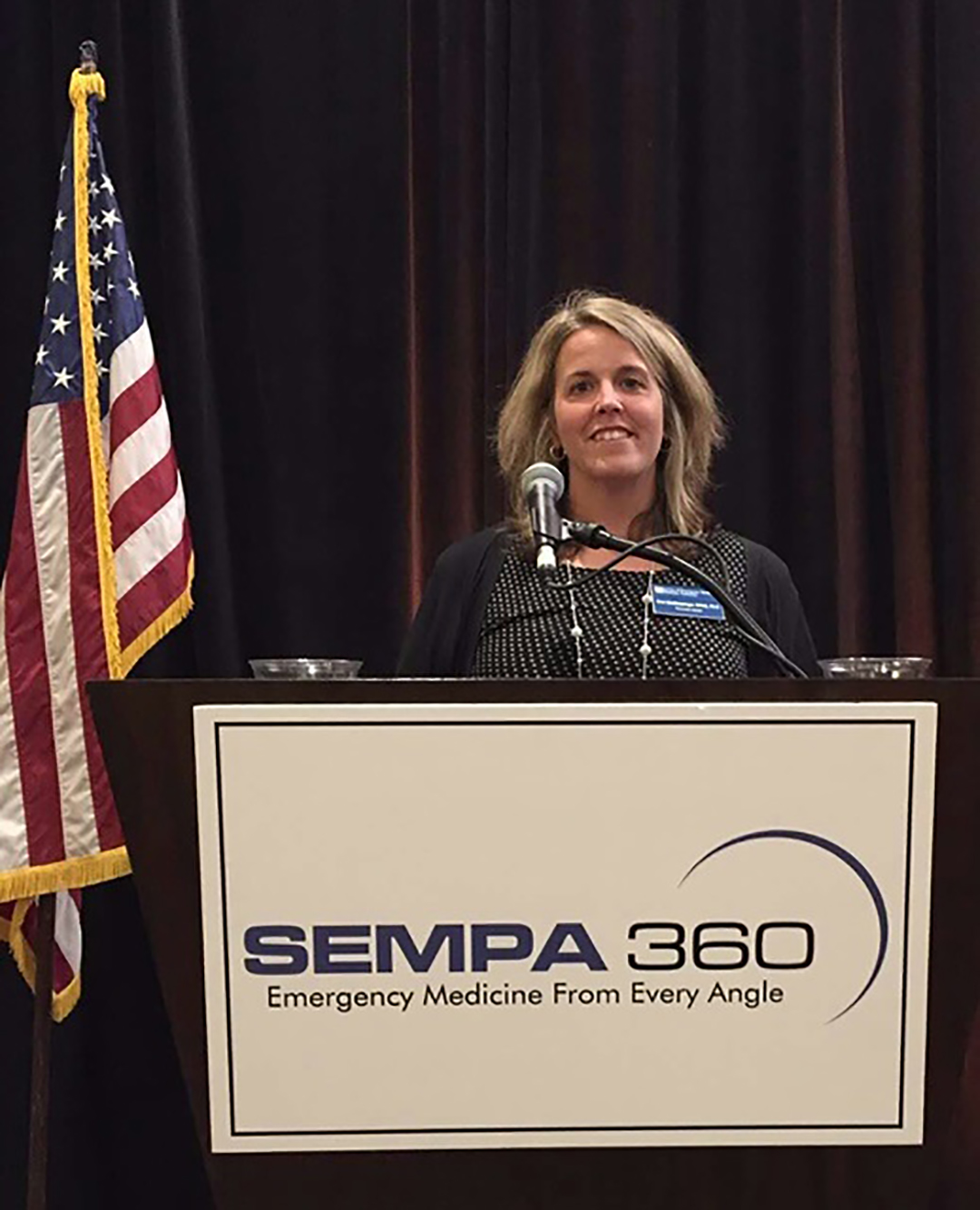 Krisi Gindlesperger stands behind a podium