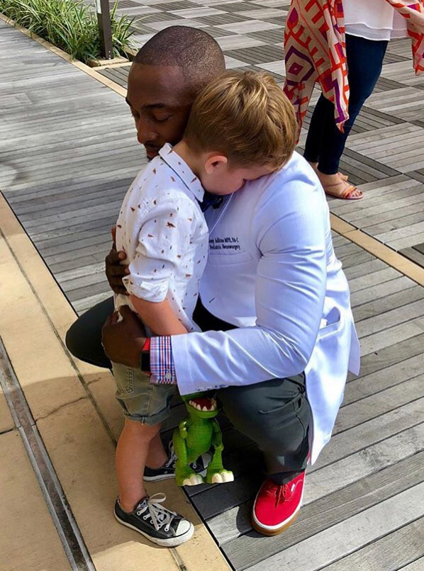 Tony Adkins hugs a young patient