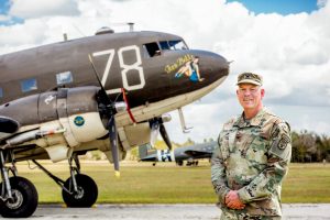 Coronel David L. Hamilton de pie cerca de un avión