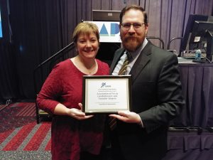 Jennifer Winter with David Burnell holding the award