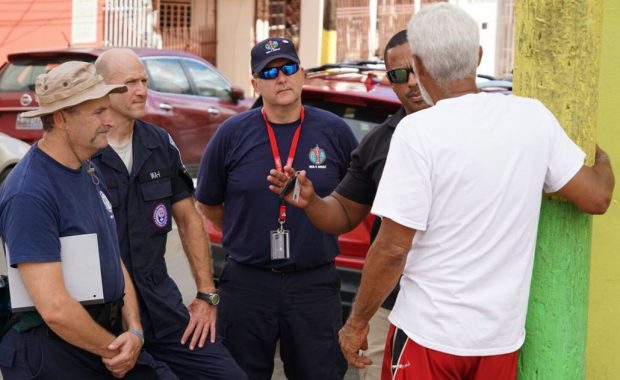 Dave Sander with a couple members of his DMAT and a Customs and Border Protection Special Unit officer talking to a local in Puerto Rico