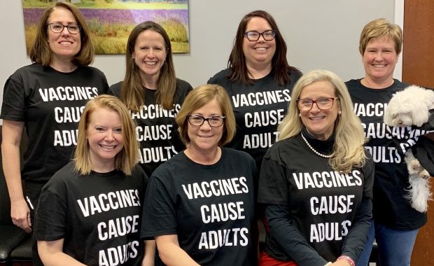 Kate Shand y sus colegas con camisetas que dicen "Las vacunas causan adultos"