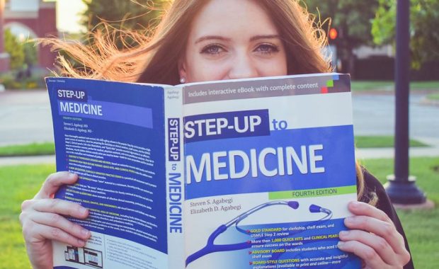 Hillary Bennett holding up a Step-Up to Medicine book