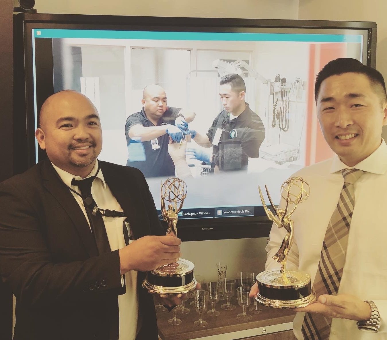 two men posing with Emmy awards