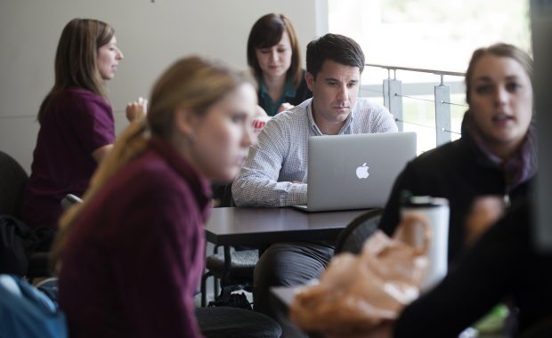 Person using a computer in room full of people