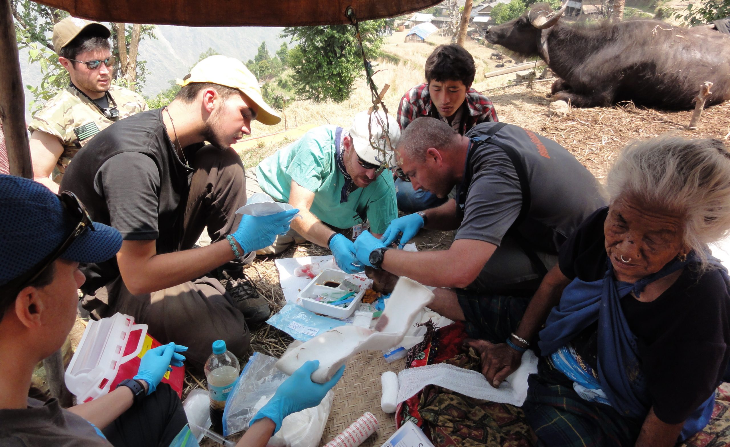 Edward Holden, PA, DHSc, DFAAPA, and his fellow volunteers address the injured foot of a woman in Nepal