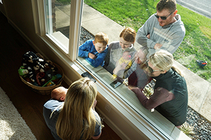 Braedon Haerling with family talking to his wife and newborn through a window