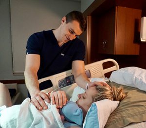 Braedon Haertling with his wife, Chelsea, holding their newborn