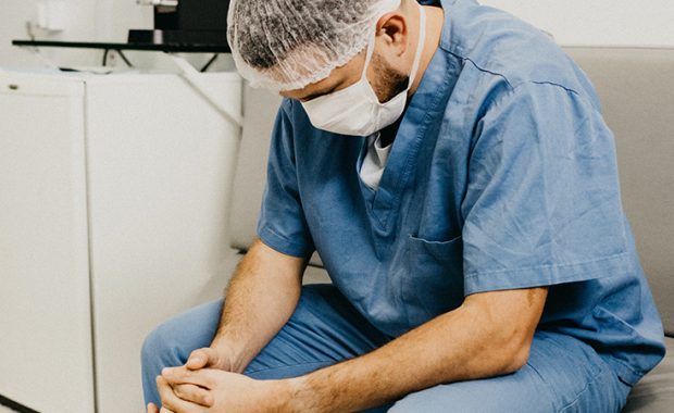 Physician associate/physician assistant sitting, looking tired