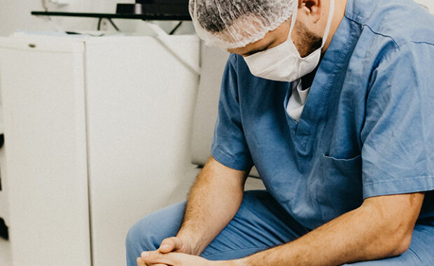 Physician associate/physician assistant sitting, looking tired