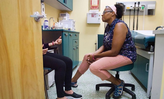 Shantae Rodriguez, PA-C, talking to a patient