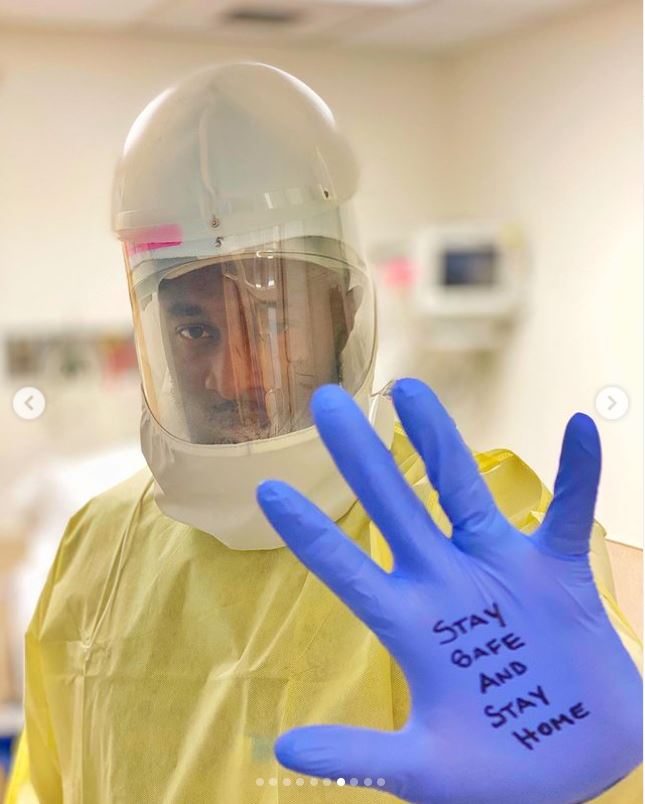 Tony Adkins en PPE, con guantes que dicen 'Mantente a salvo y quédate en casa'