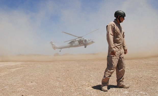 William Eisenhart turns away from a cloud of dust during fast roping evolutions for a basic tactical training class