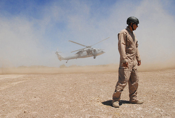 Explosive Ordnance Disposal 1st Class William Eisenhart, turning away from a cloud of dust