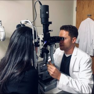 Joel Ciolek examining a patient's eye