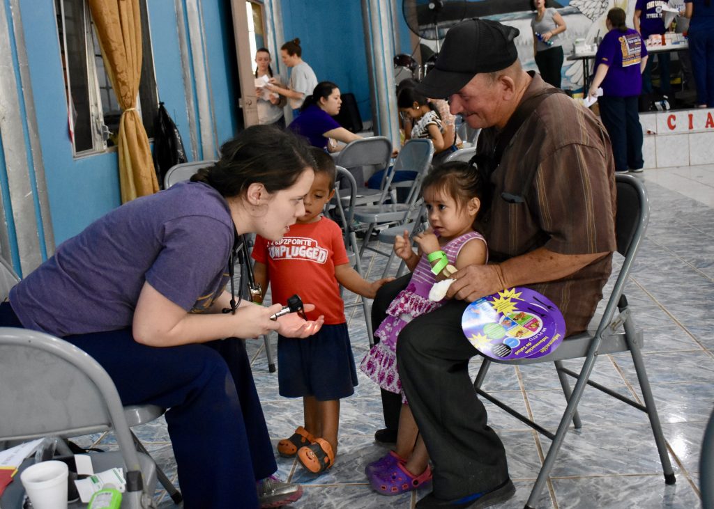 A member of the ECU team consults with a family during the team’s trip to Taulabé, Honduras