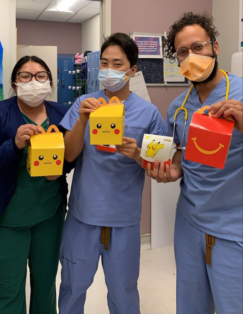 Omar Razack, PA-C, and his PA colleagues holding Happy Meals