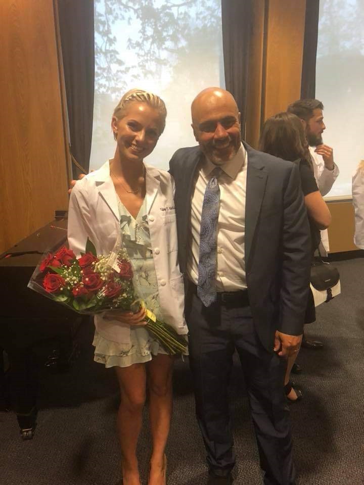 PA (physician associate/physician assistant) Andrew Case stands with a student at a white coat ceremony