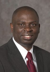 Headshot of a man wearing a suit jacket and tie.